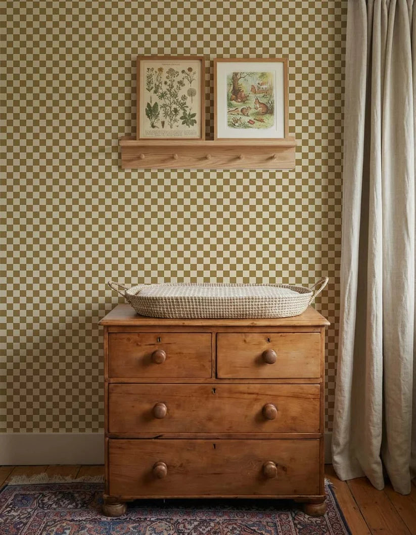 Dambord Olijfgroen – Atelier Chien : papier peint derrière une commode en bois avec panier à langer.