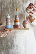 Celebrate Activity Toy – Bloomingville MINI: close-up of a hand placing a piece on a stack.